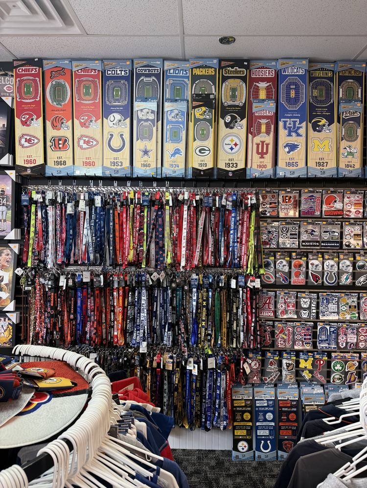 Rows of team lanyards and keychains under 3D stadium wall art boxes