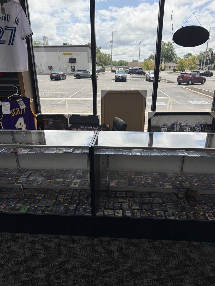 Glass showcase filled with rows of sleeved and graded cards