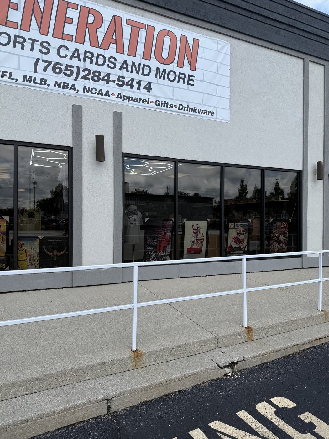 The storefront and parking lot seen from the sidewalk ramp