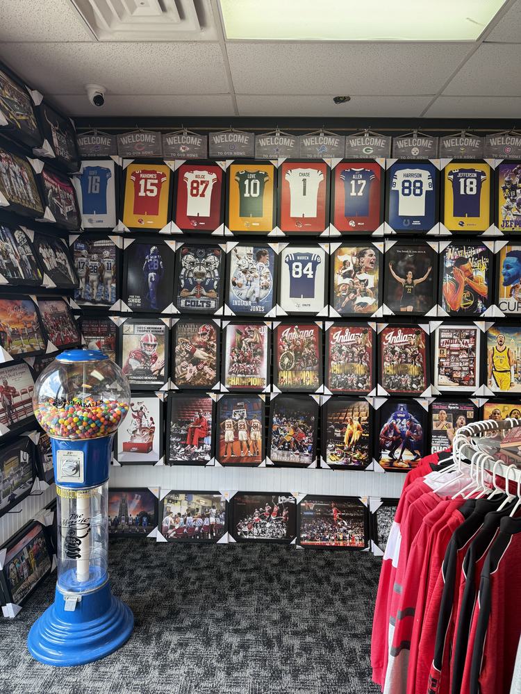 Wall of framed player canvas prints and team welcome signs